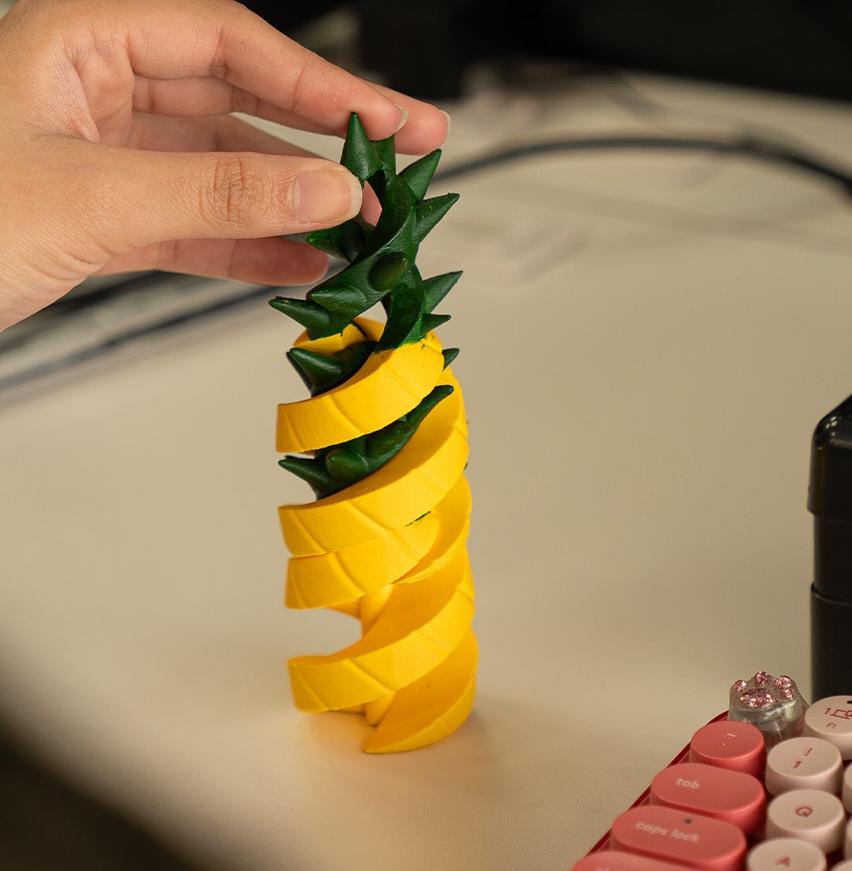 Hand holding a pineapple-shaped object with a blurred background
