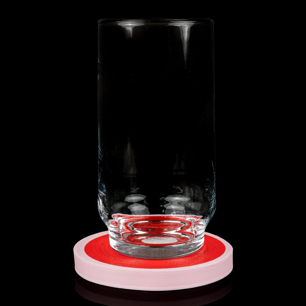 A glass standing on a pork chop coaster