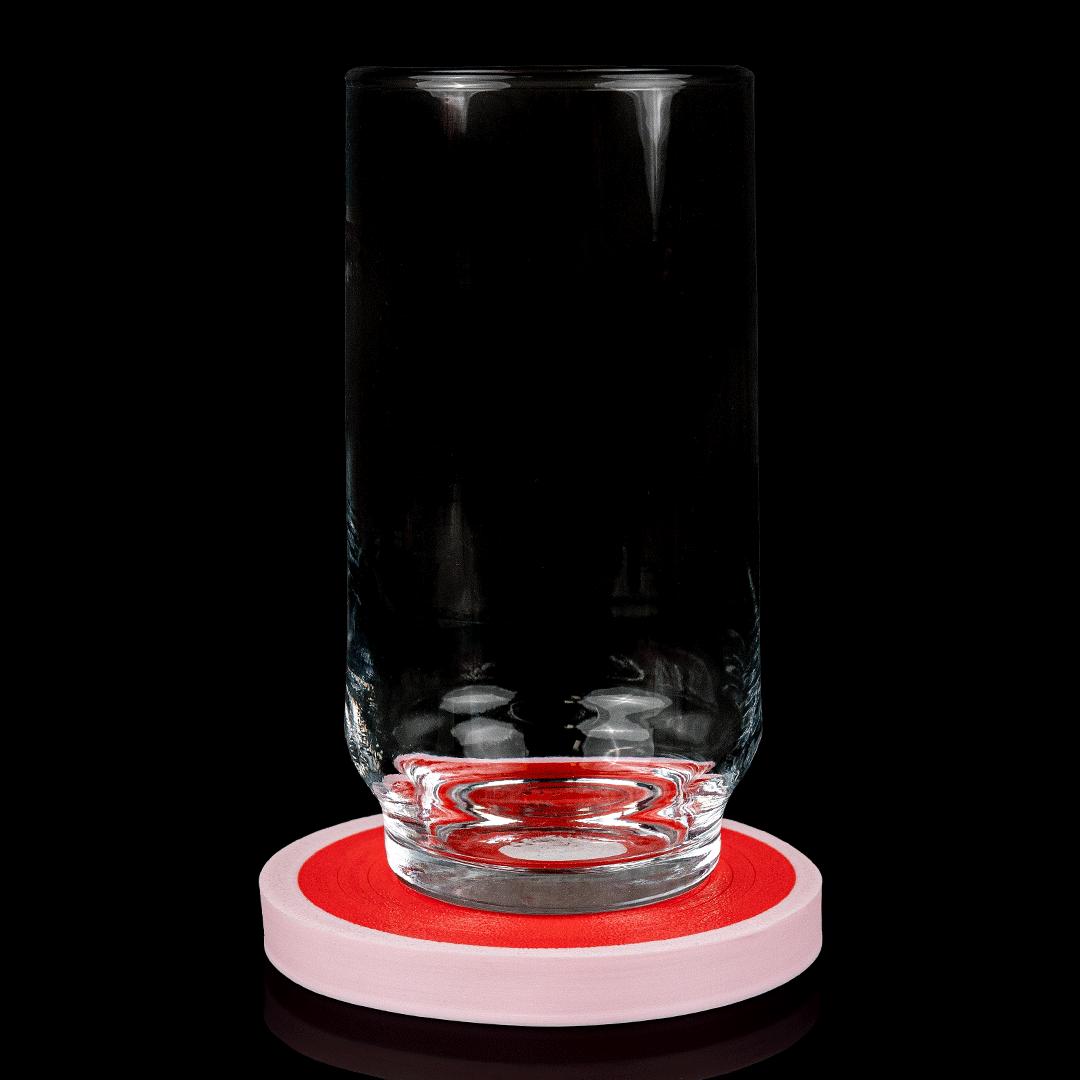 A glass standing on a pork chop coaster