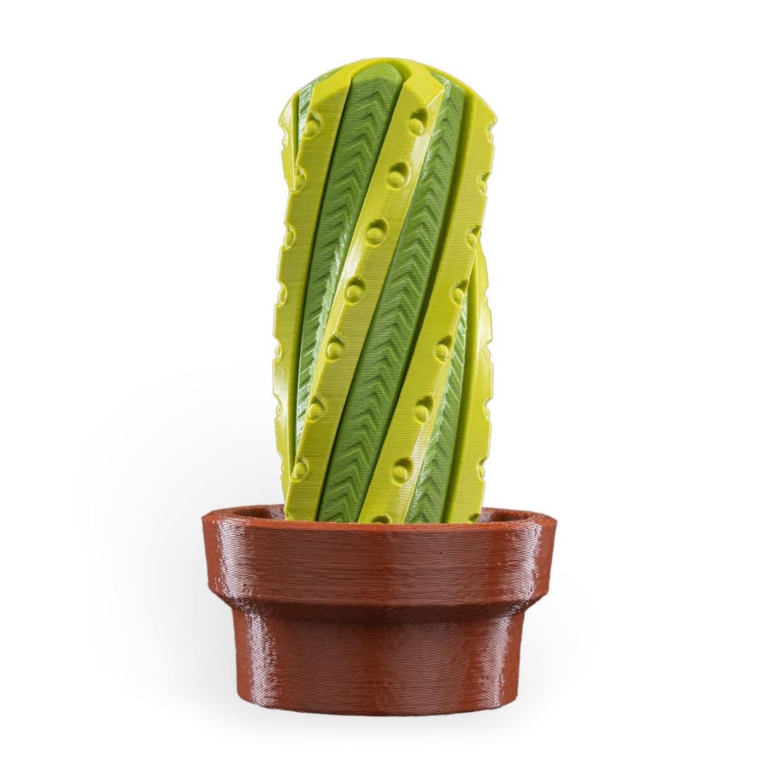 Green cactus-shaped object in a brown pot on a white background