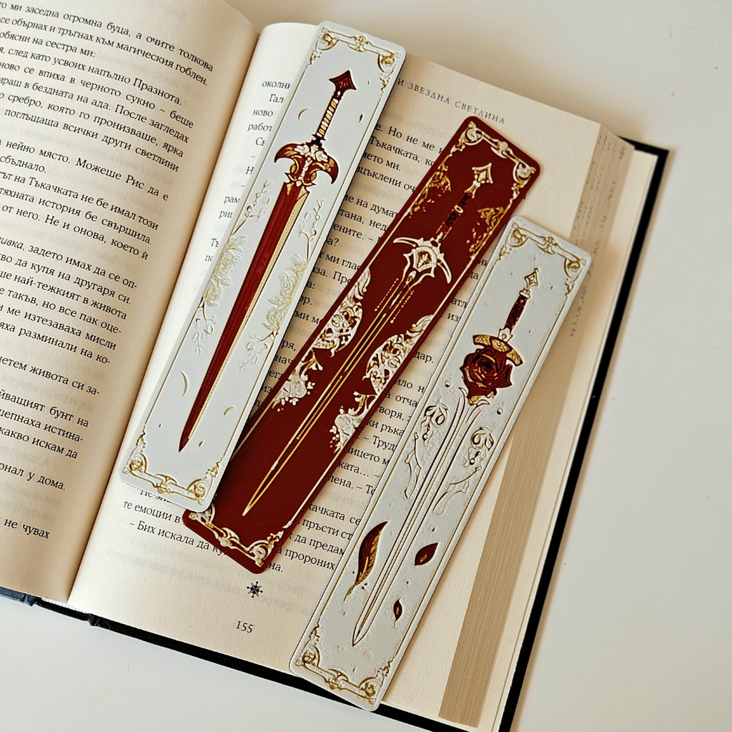 Decorative bookmarks with sword designs on an open book