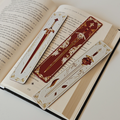 Decorative bookmarks with sword designs on an open book