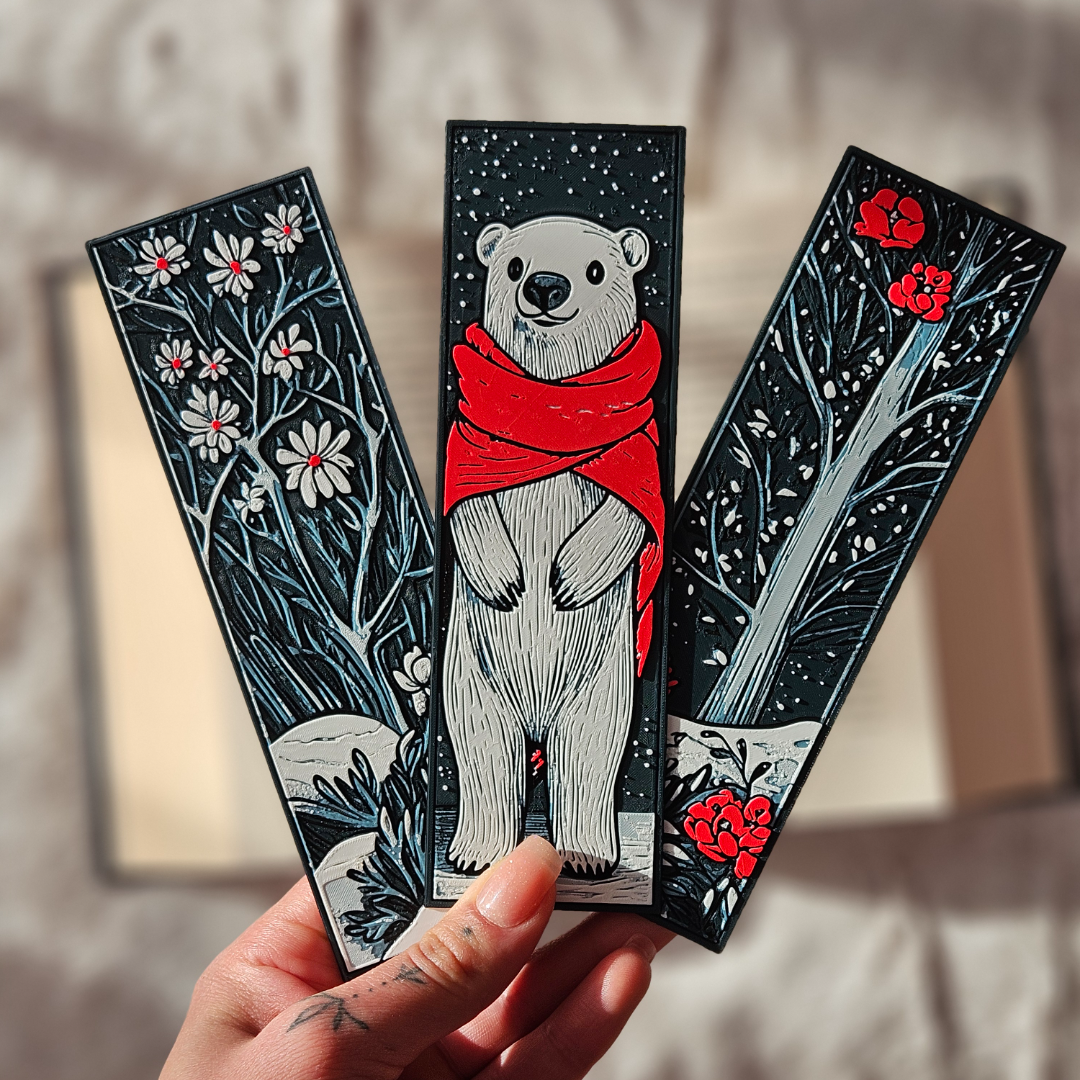 Three decorative bookmarks featuring a polar bear, flowers, and a sword.