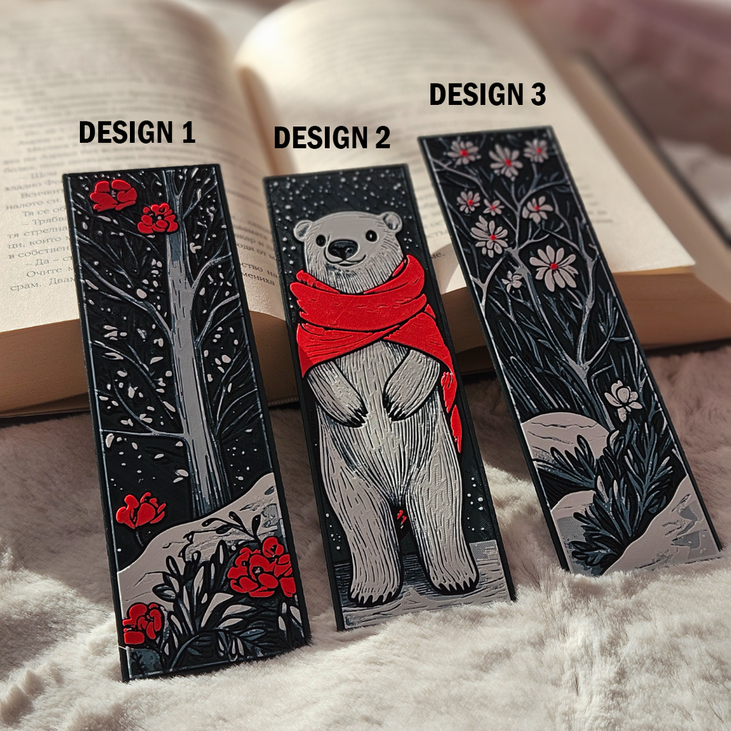 Three decorative bookmarks with different designs on a soft surface.
