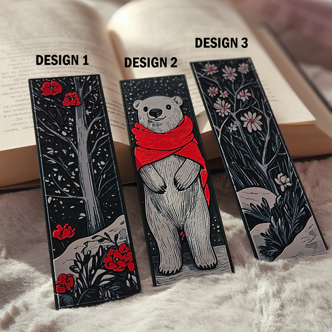 Three decorative bookmarks with different designs on a soft surface.