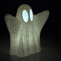 Ghost-shaped light with glowing eyes on a black background