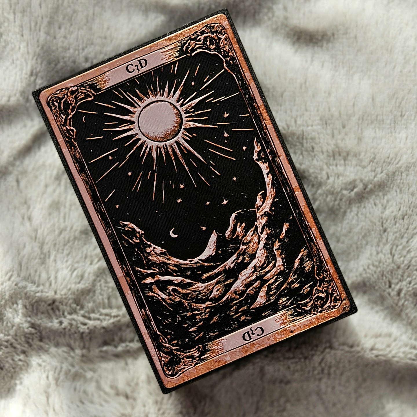 Decorative card with sun and moon design on a textured surface