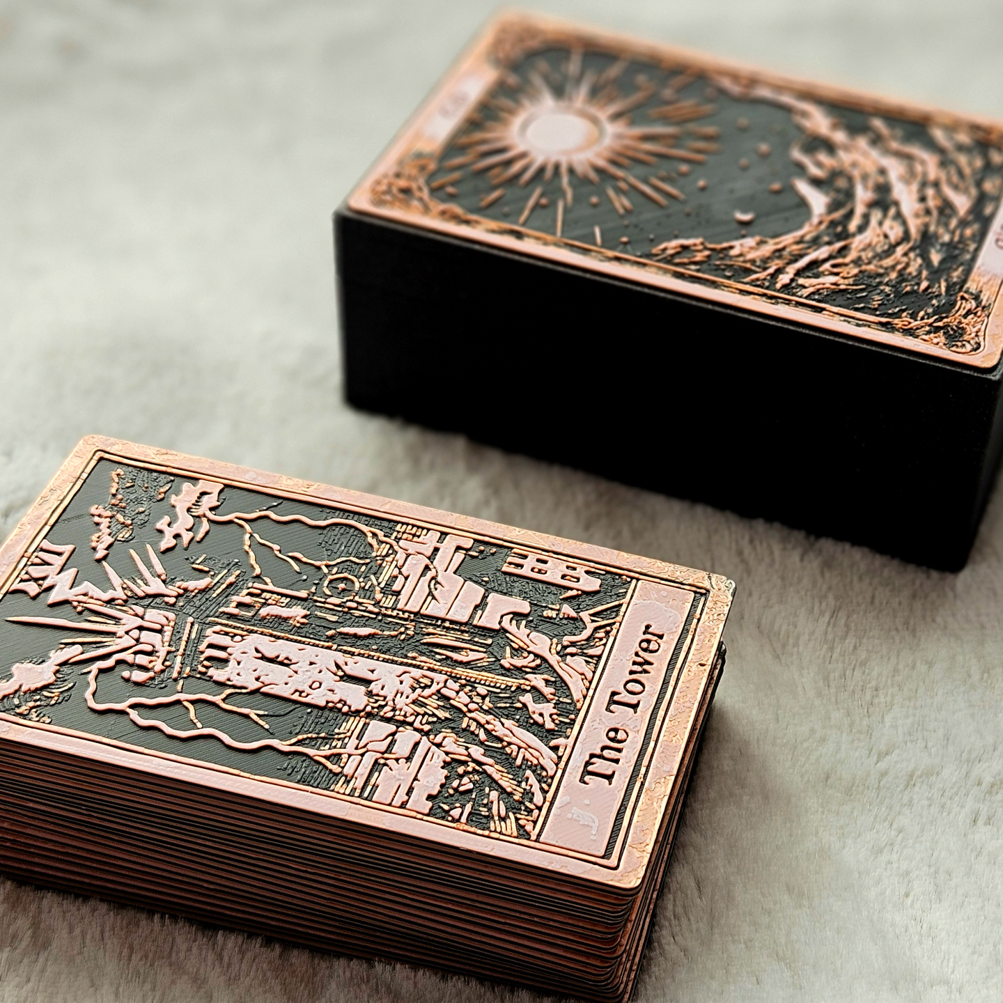 Decorative card box with intricate designs and 'The Tower' text on a textured surface