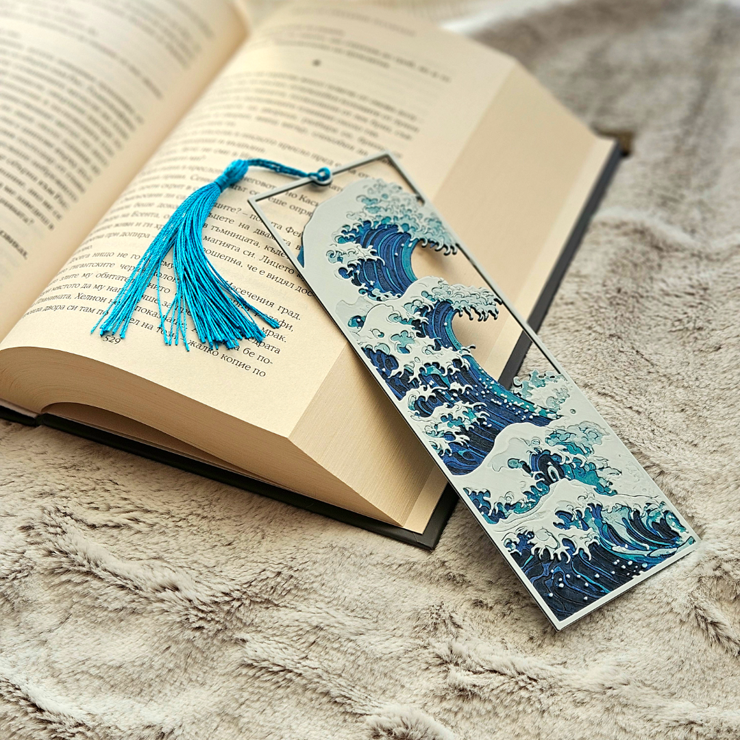 Bookmark with wave design and blue tassel on an open book