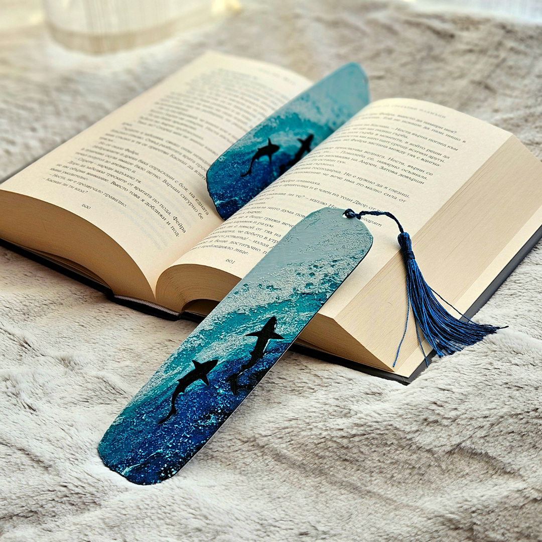 Two blue bookmarks with shark designs on an open book.