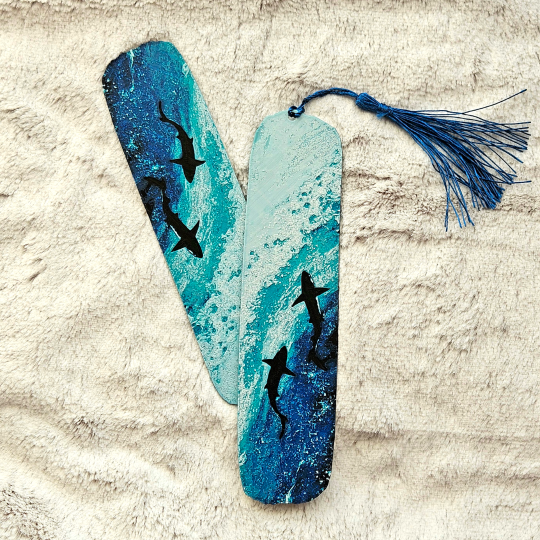 Bookmark with shark design and tassel on a textured surface