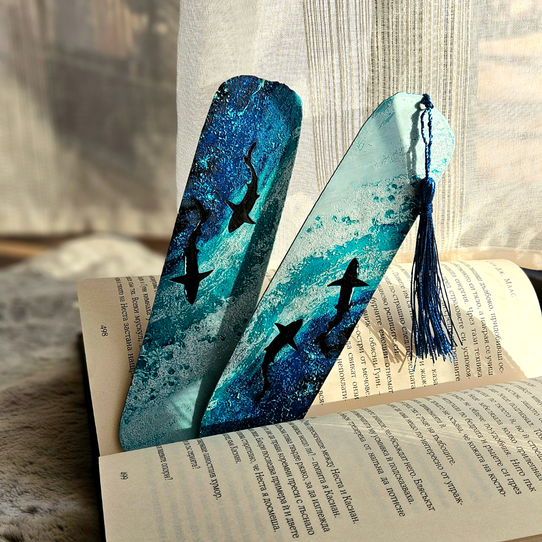 Blue and black shark design bookmark with tassel on an open book