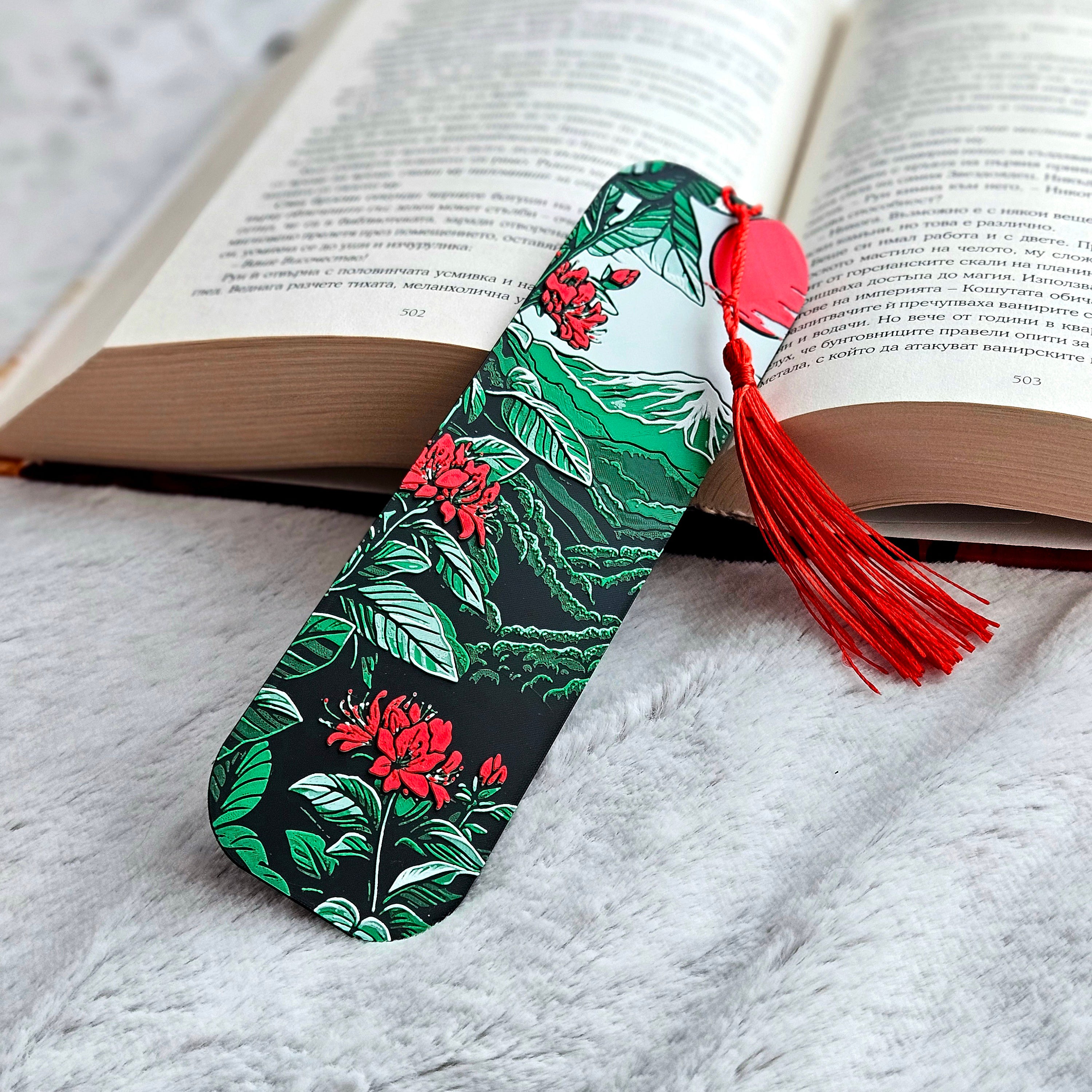 Floral bookmark with a red tassel on an open book