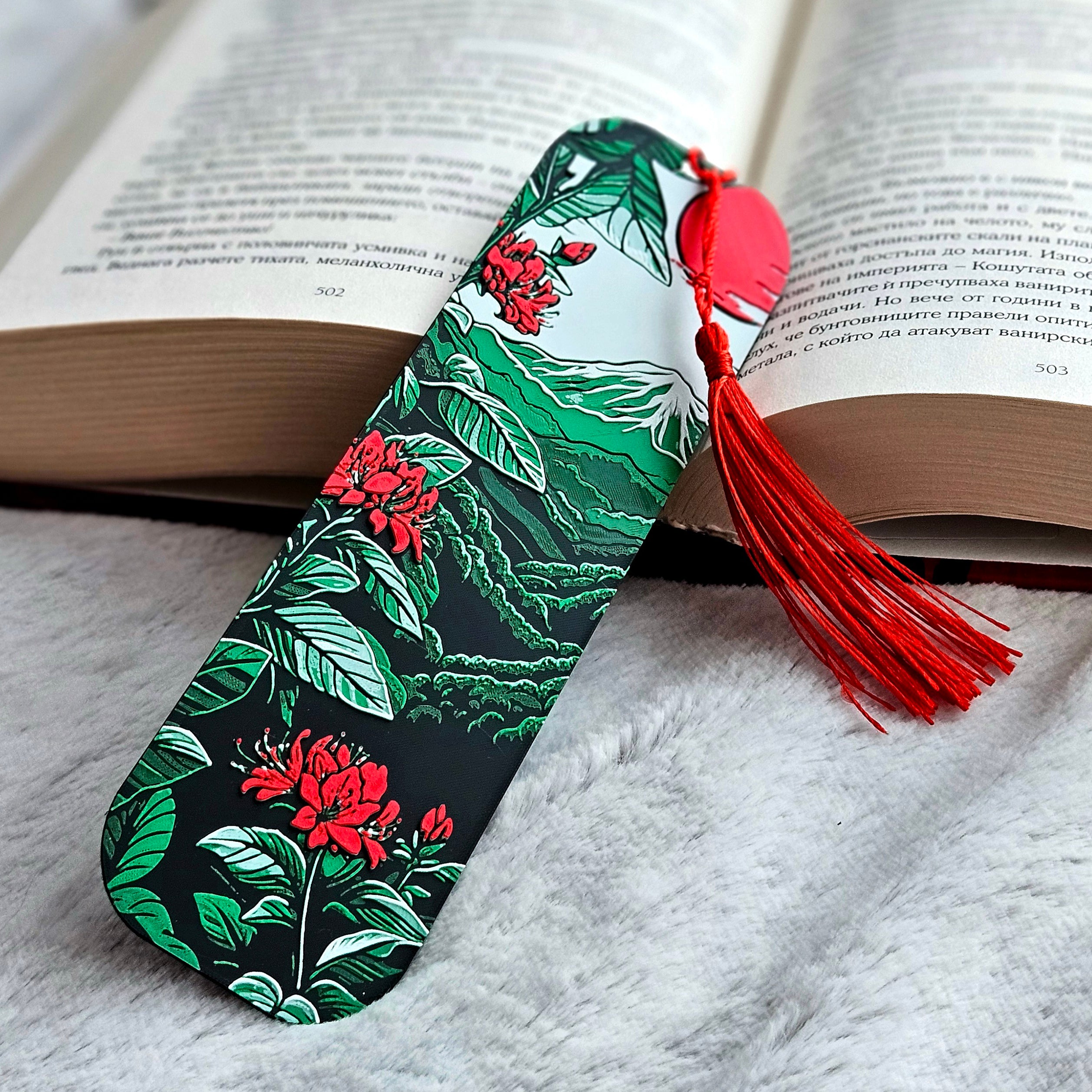 Floral bookmark with a red tassel on an open book