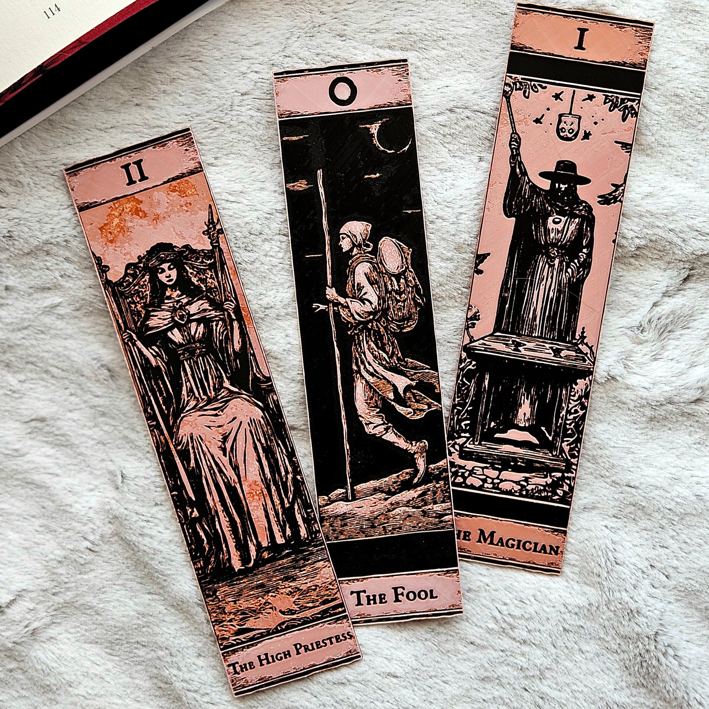 Three tarot card bookmarks on a textured surface