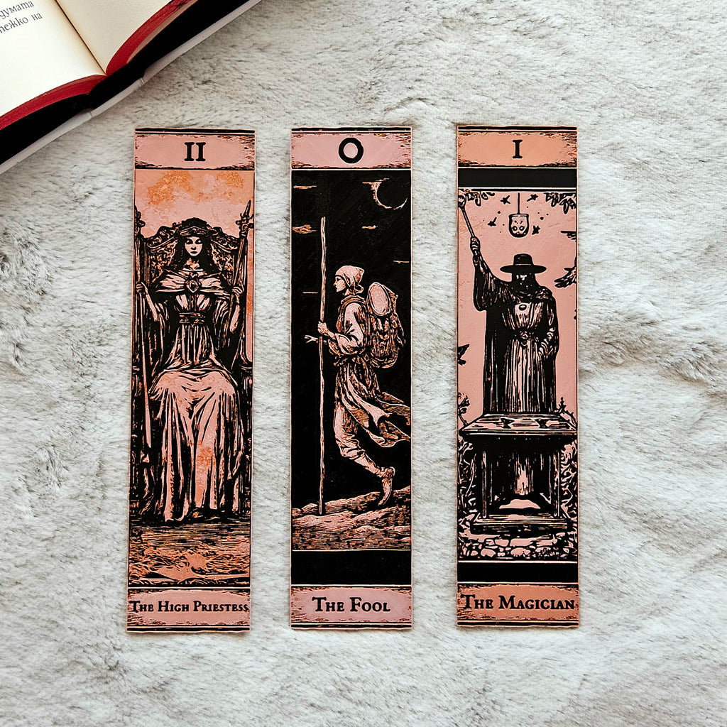 Three tarot card bookmarks on a textured surface