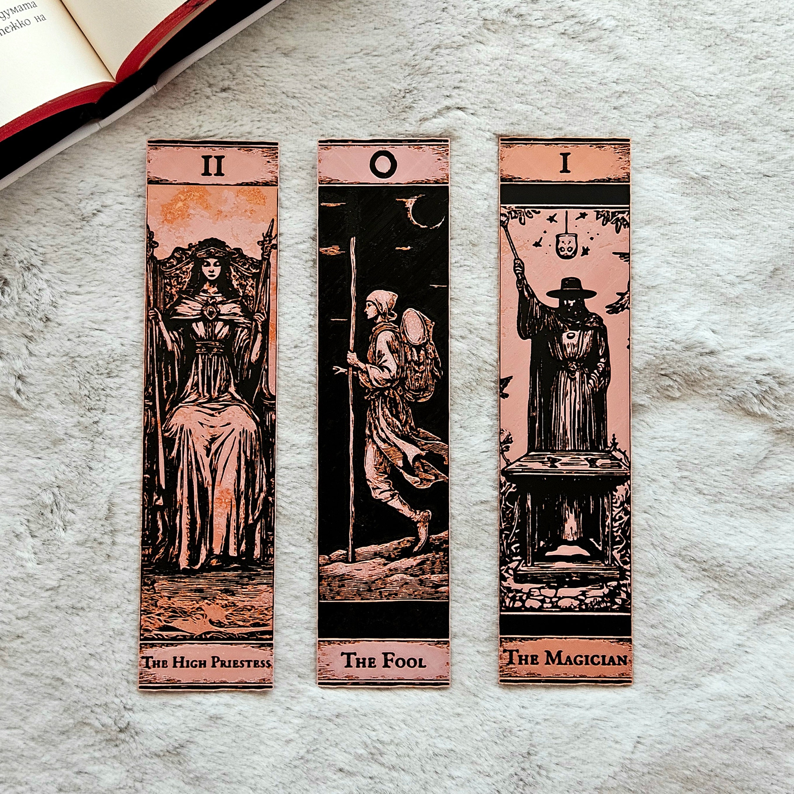 Three tarot card bookmarks on a textured surface