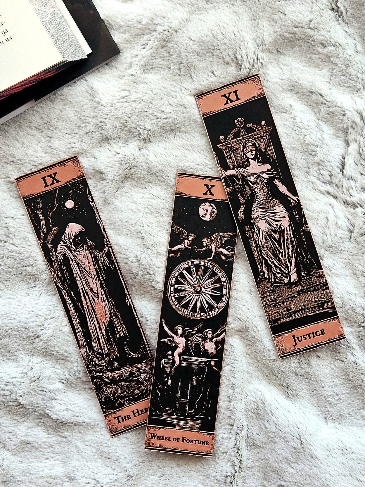 Three tarot card bookmarks on a textured surface