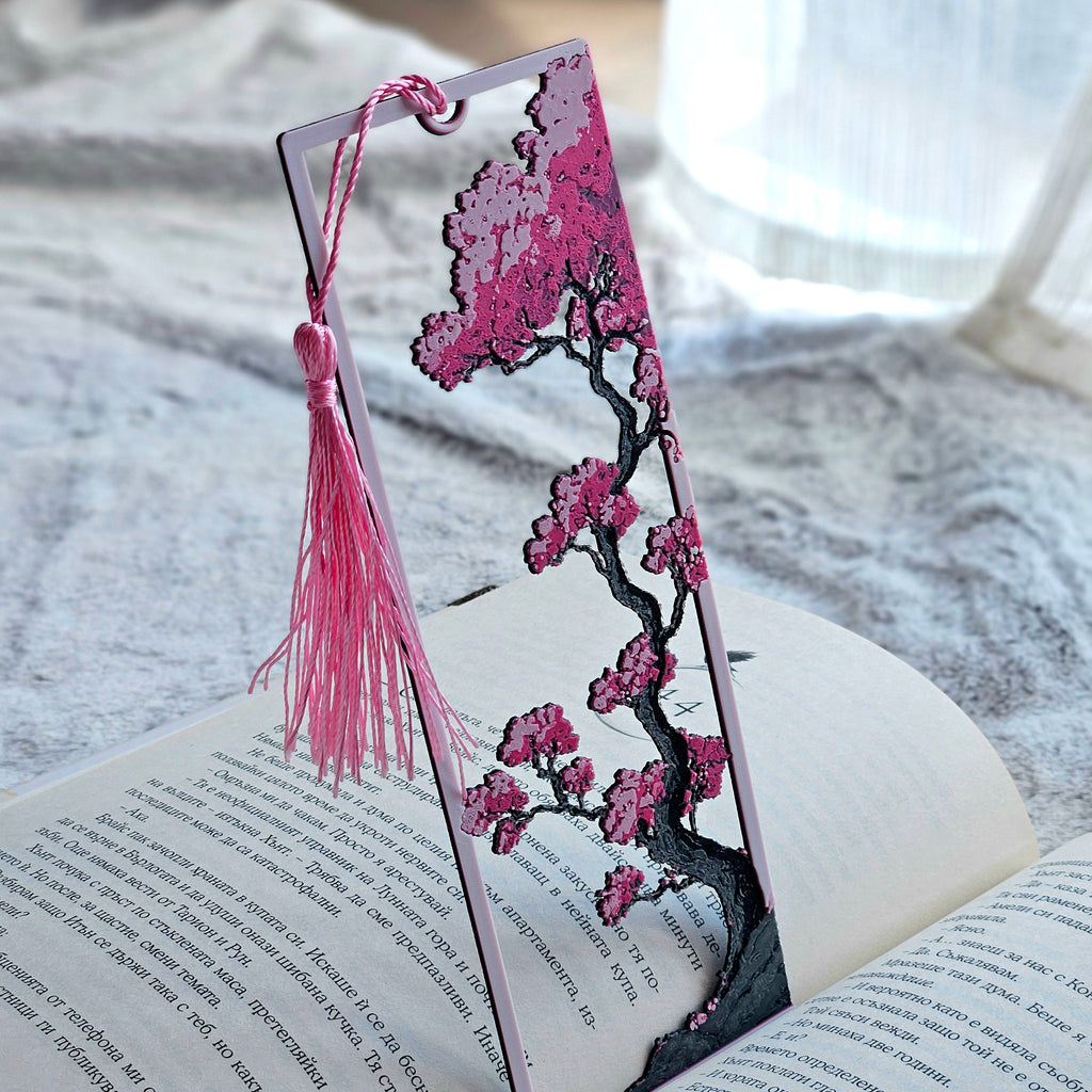 Decorative bookmark with cherry blossom design on an open book