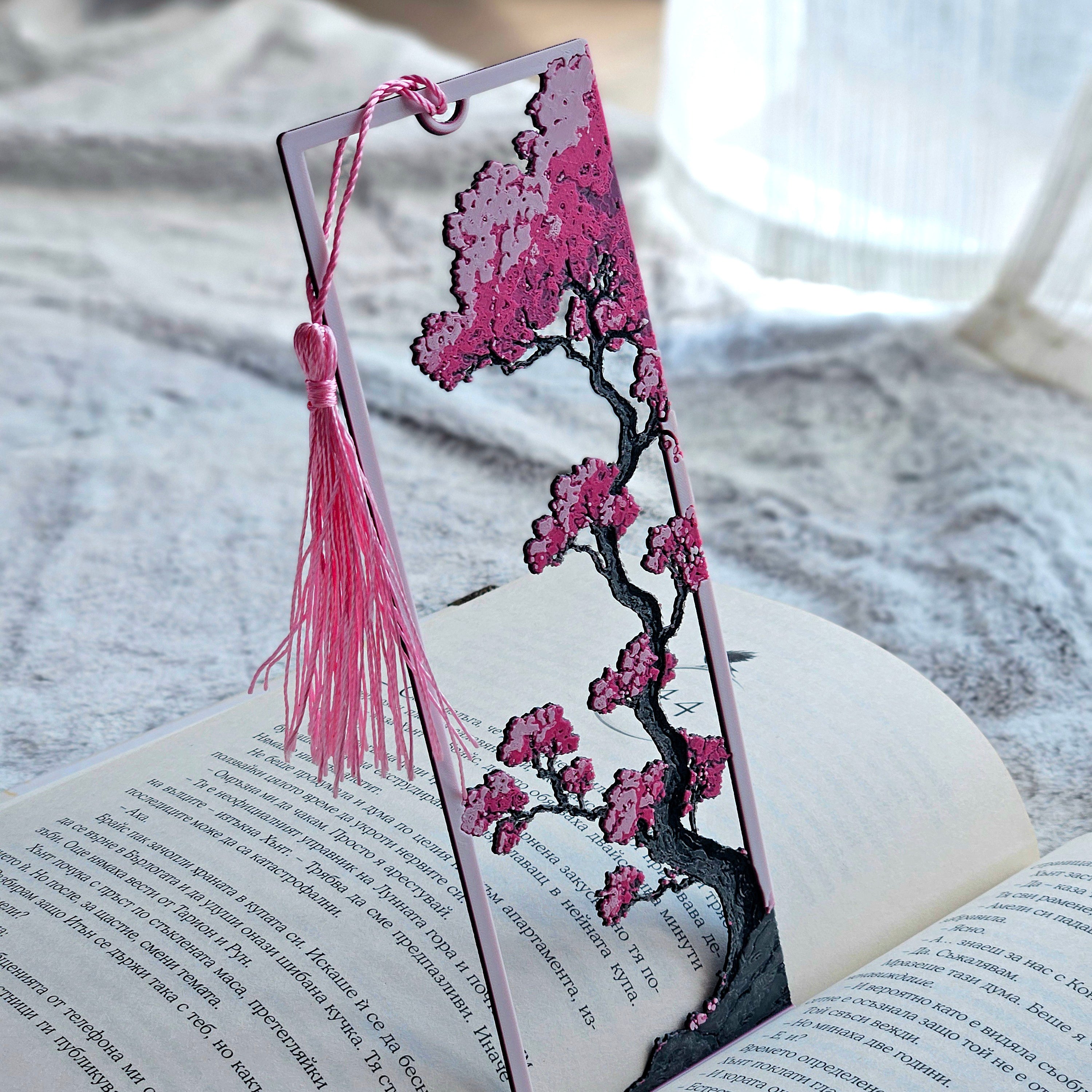 Decorative bookmark with cherry blossom design on an open book