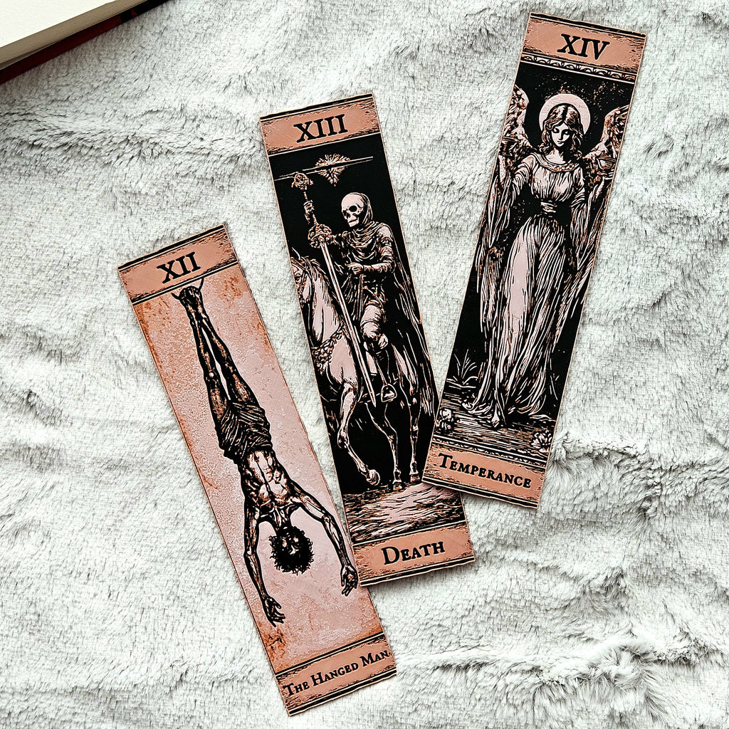 Three tarot cards labeled 'The Hanged Man', 'Death', and 'Temperance' on a textured surface.