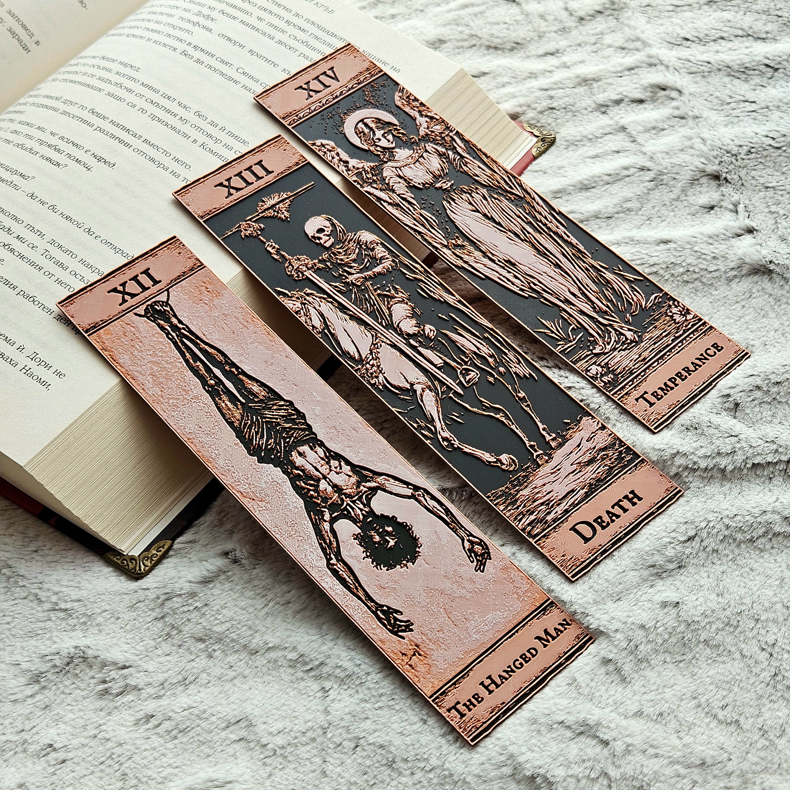 Wooden bookmarks with tarot card designs on an open book
