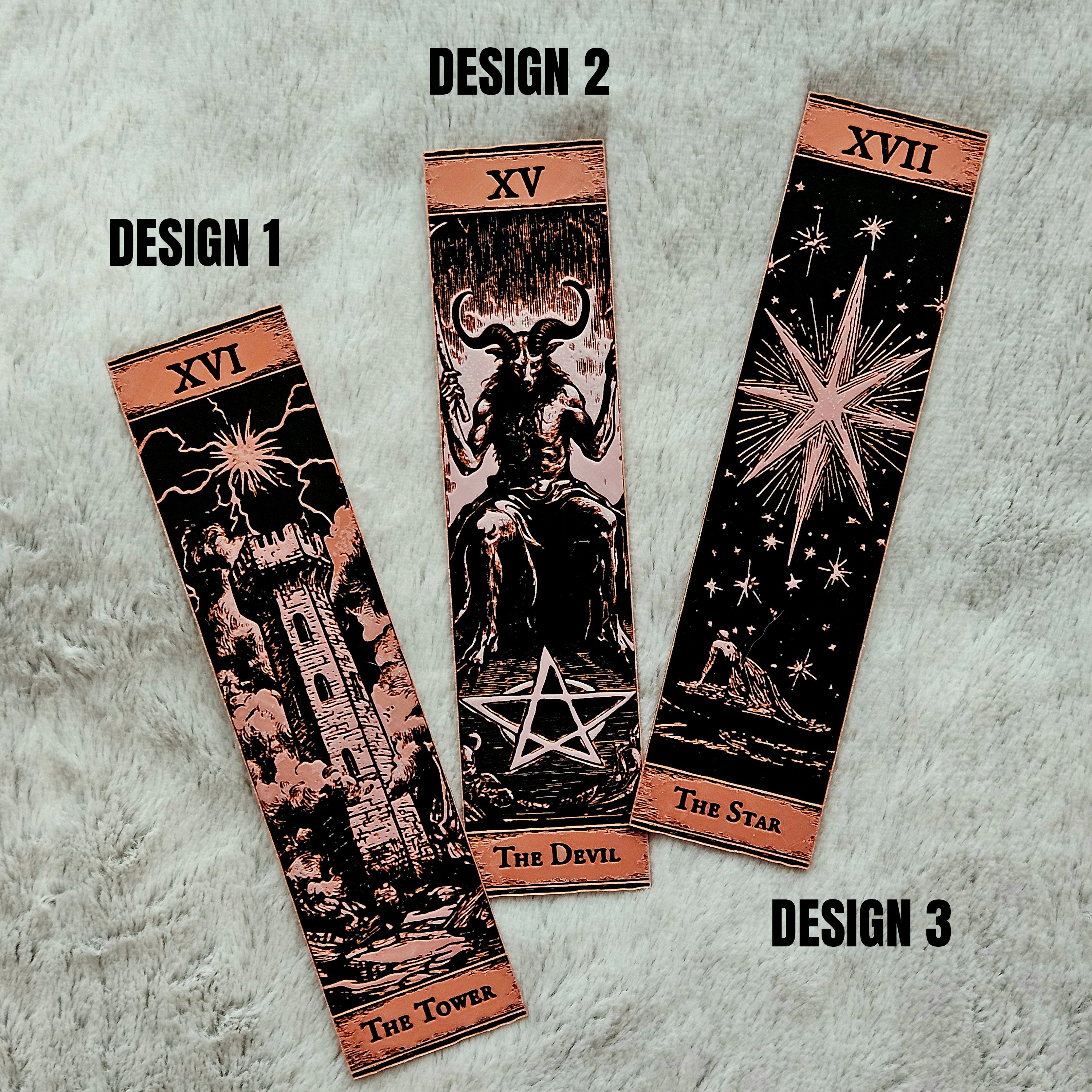 Three tarot card designs on a textured gray background