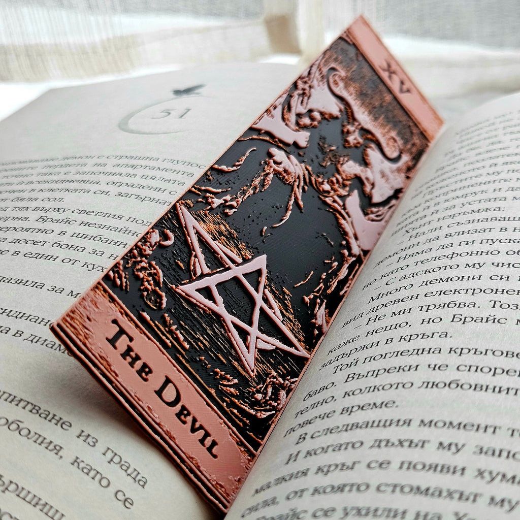 Decorative bookmark with 'The Devil' design on an open book