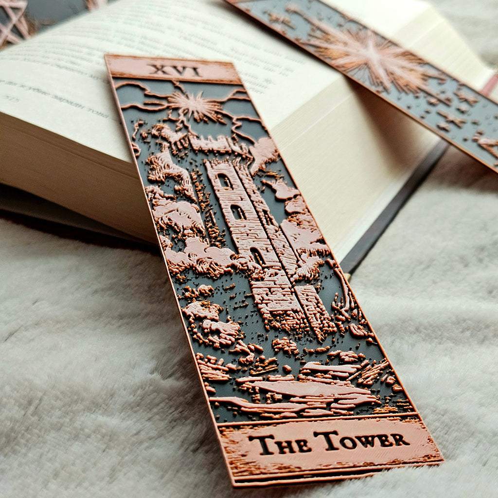Decorative tarot card bookmark titled 'The Tower' on an open book.