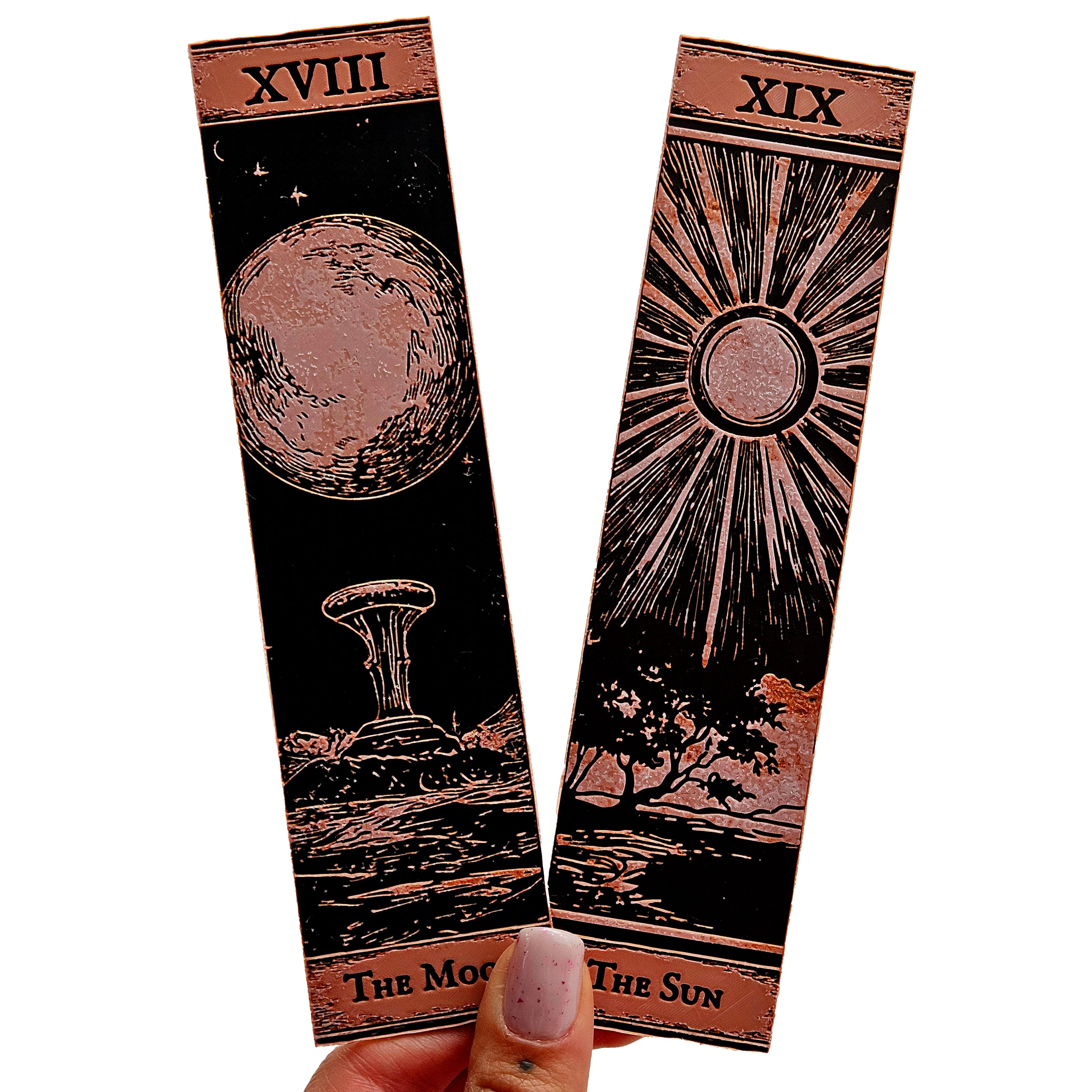 Two tarot card designs, 'The Moon' and 'The Sun', held by a hand on a white background.