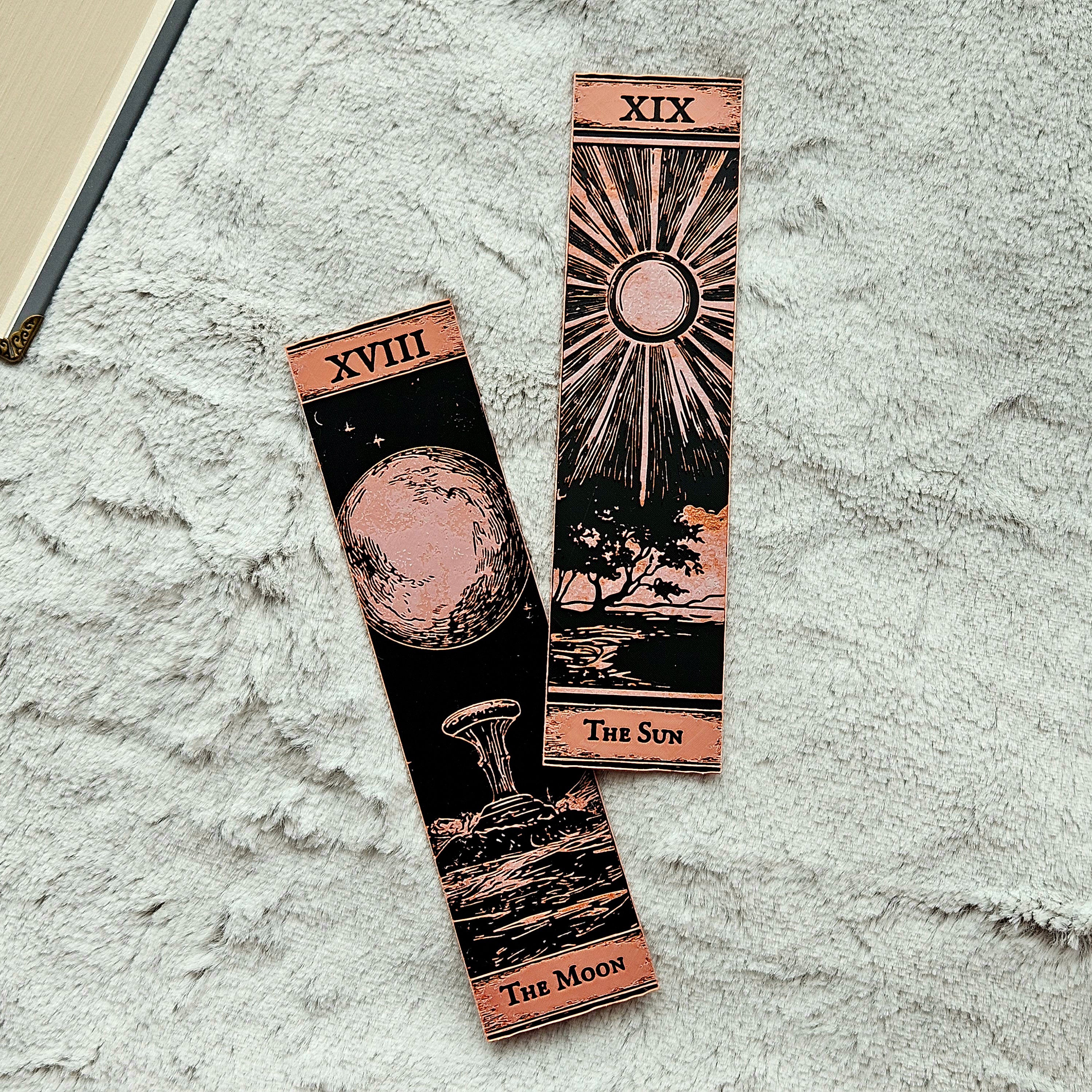 Two tarot card-style bookmarks on a textured surface