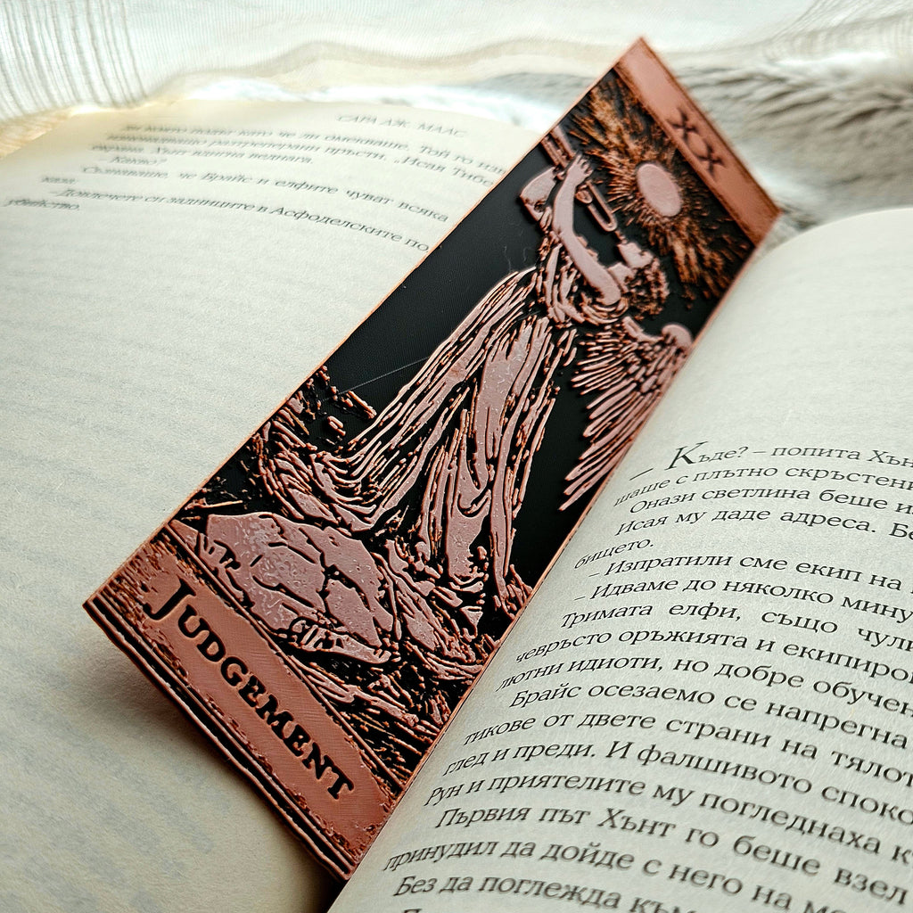 Book with a bronze bookmark featuring an illustration of a figure labeled 'Judgement' on a light background.