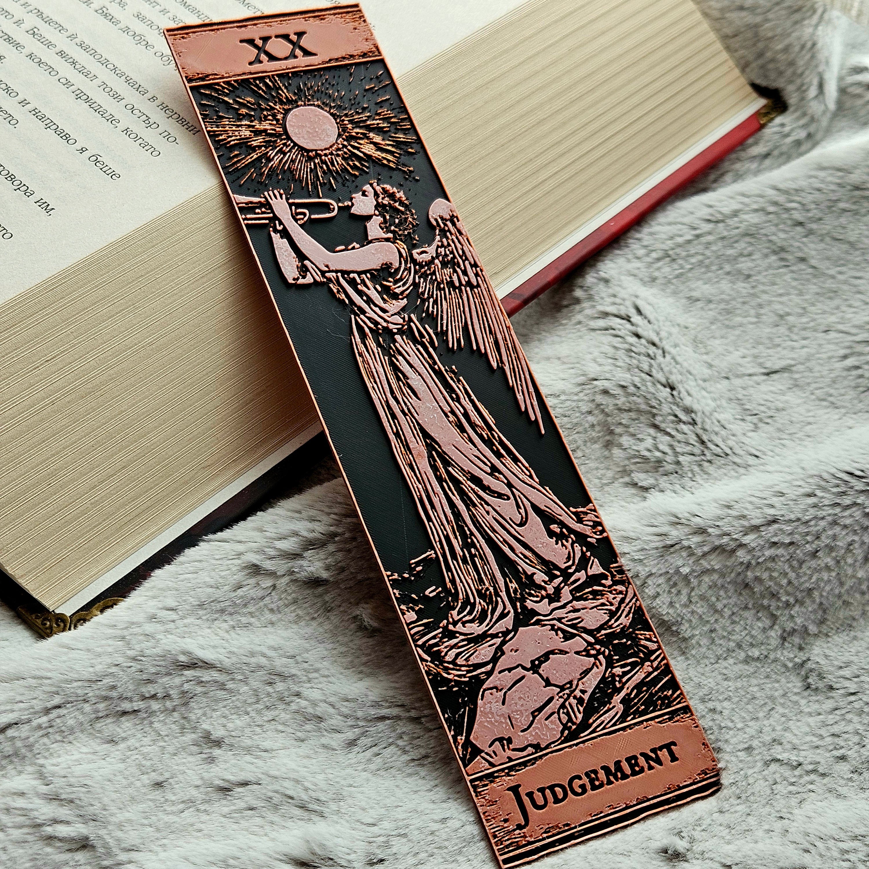 Decorative bookmark with angel design and 'Judgment' text on an open book.