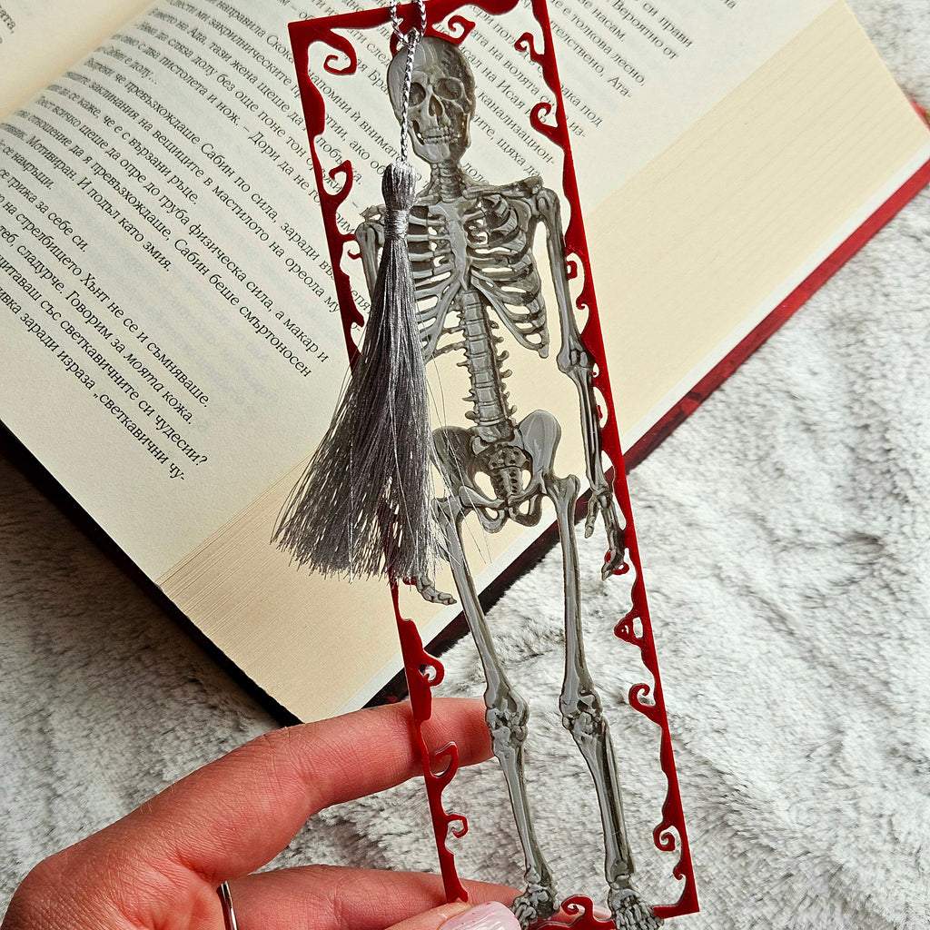 Skeletal bookmark with red decorative elements on an open book