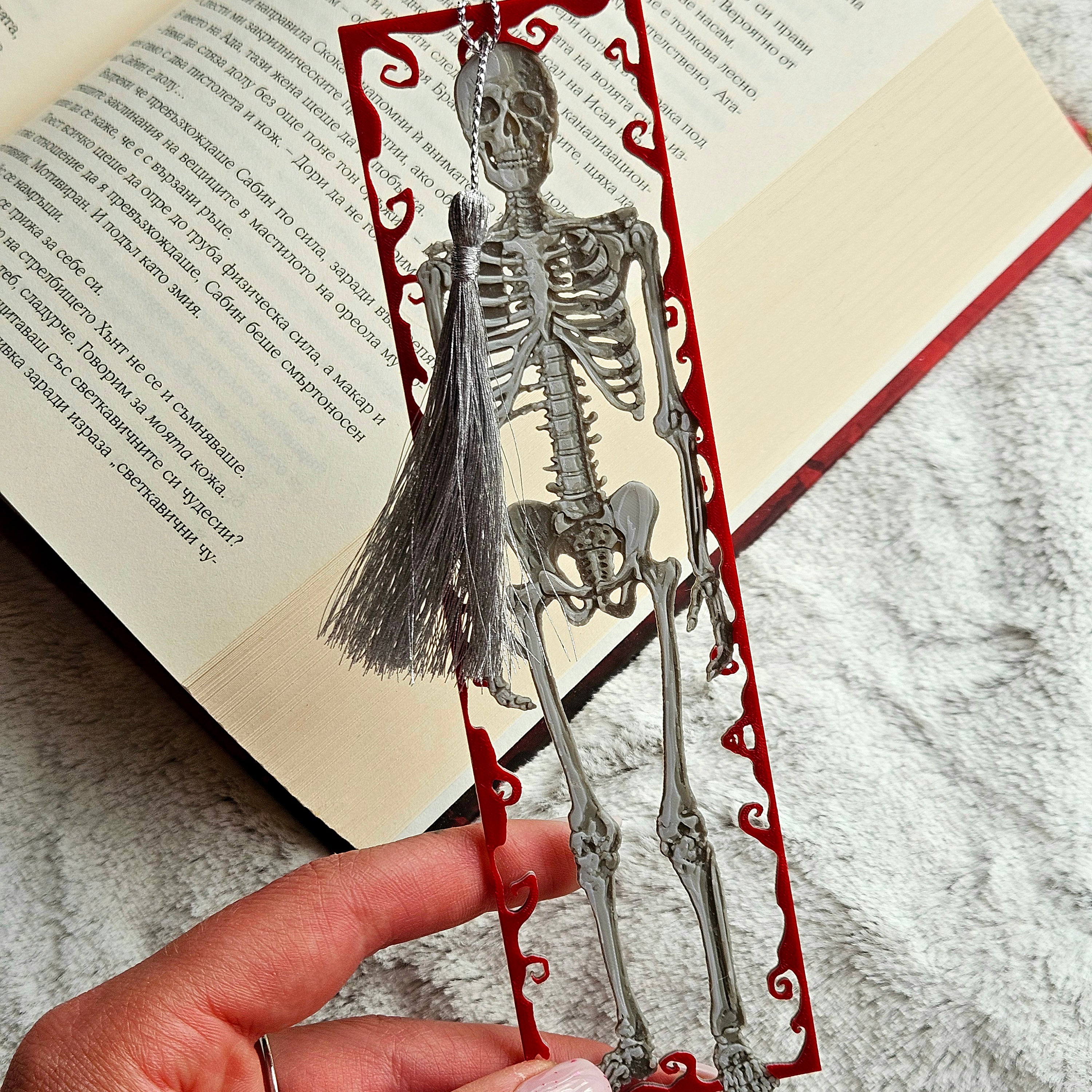 Skeletal bookmark with red decorative elements on an open book