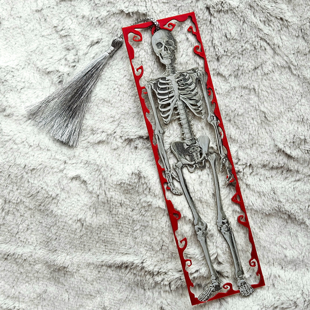 Skeletal bookmark with red decorative border on textured surface