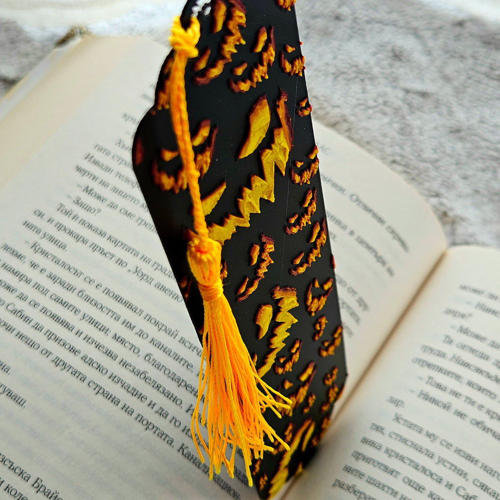 Decorative black and gold bookmark with tassel on an open book