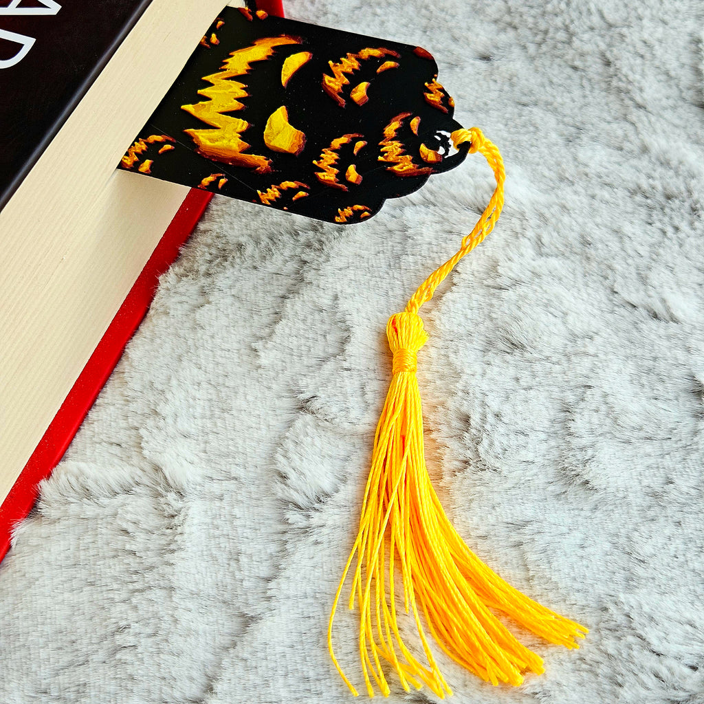 Decorative bookmark with a black and yellow design on a textured surface