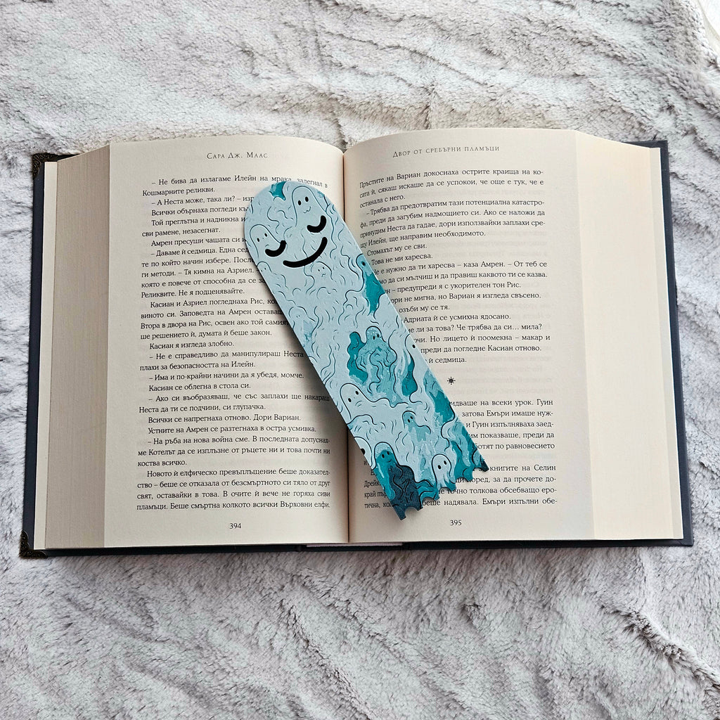 Open book with a blue bookmark featuring cartoon characters on a gray textured surface
