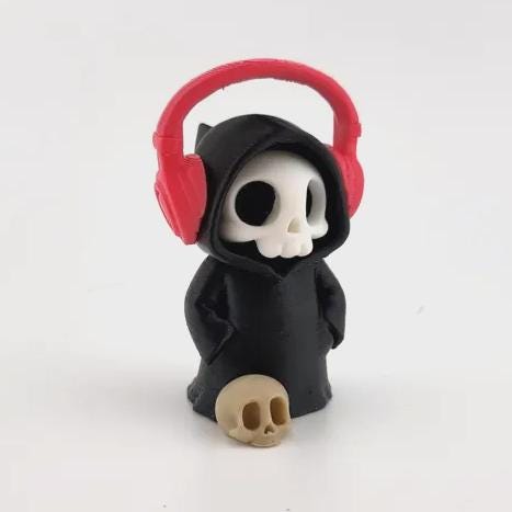 The Audiophile grim reaper wearing red headphones, with a little skull at its feet
