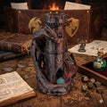 Twin Dragons dice tower on a gaming table with dice, books and a potion bottle