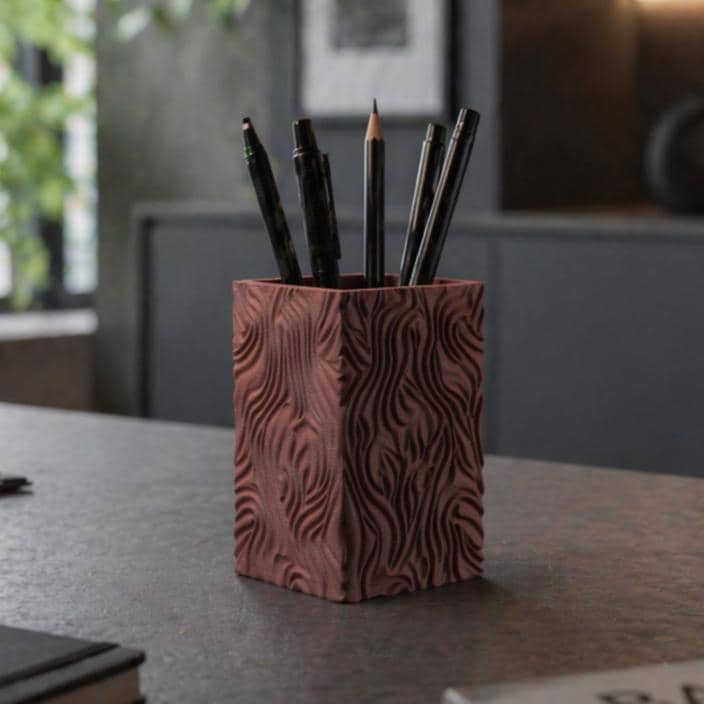 Terracotta wavy texture pencil holder with pens on a desk