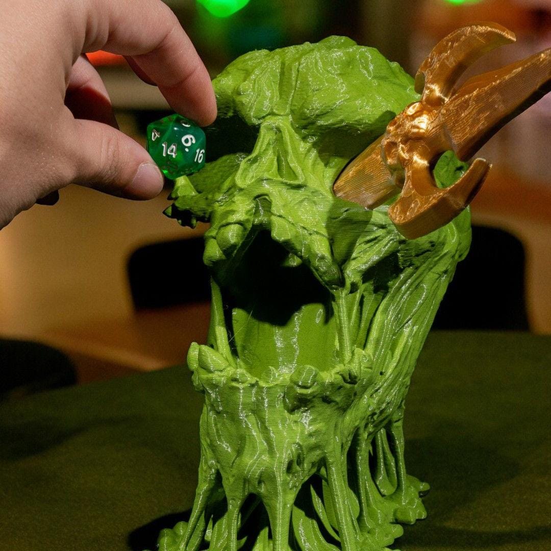 Green creature figure with gold weapon and hand holding a green die.