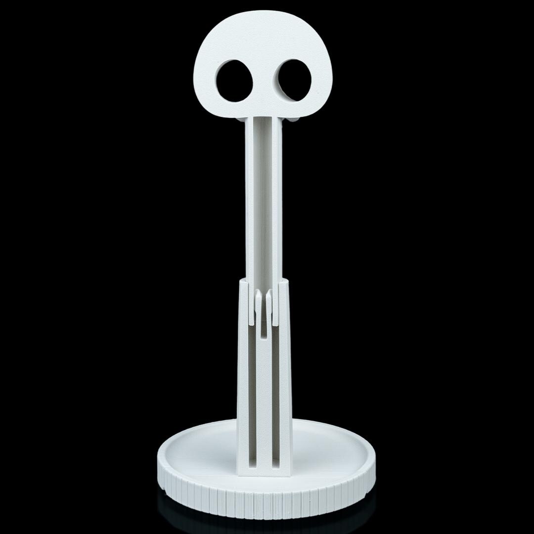 White skull headphone stand from behind, showing the fluted column