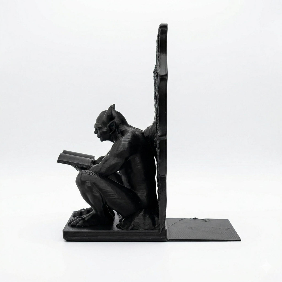 Gargoyle bookend from the side, showing the flat base that slides under the books