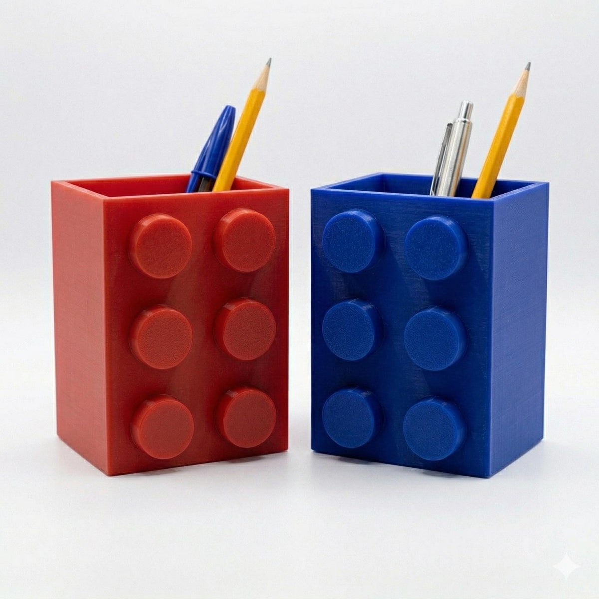 Red and blue building brick pencil pots with pens and pencils