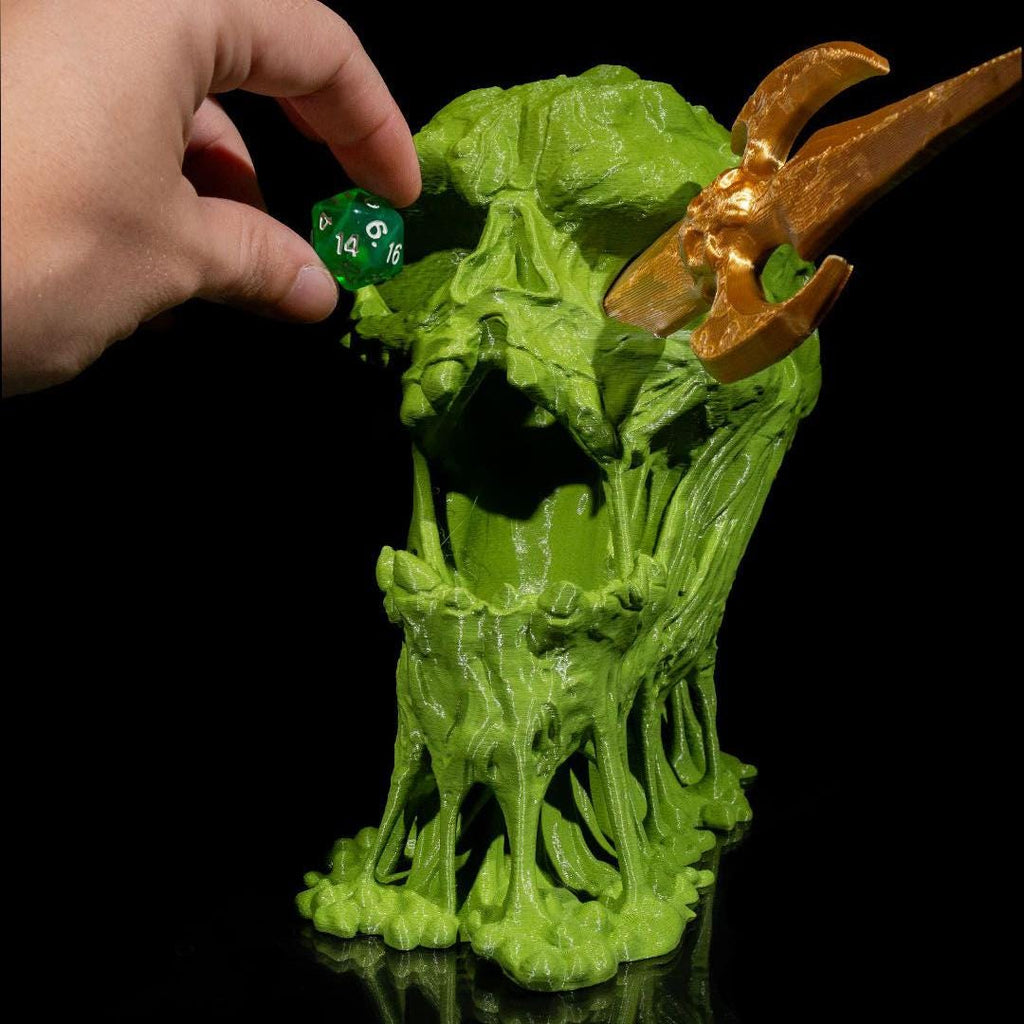 Green dragon-like creature with a hand holding a green die against a black background