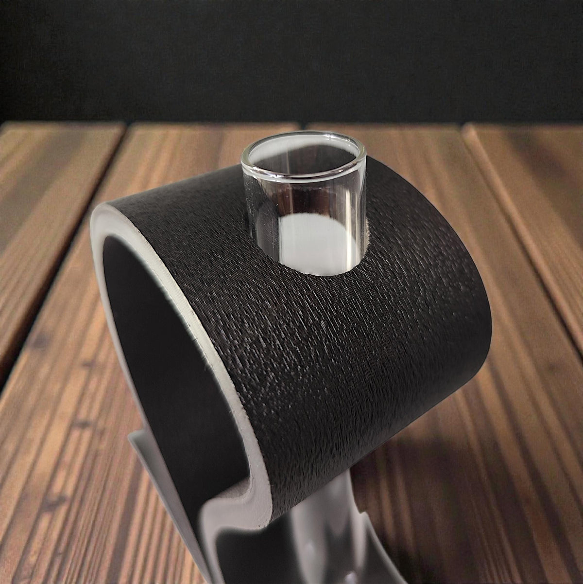 Close-up of the black stand with its glass tube