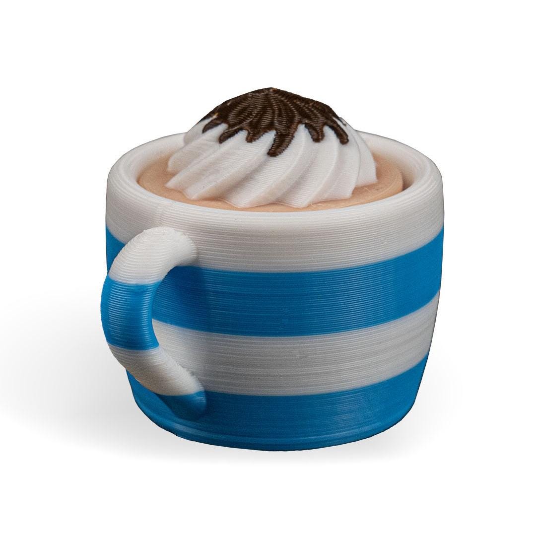 Blue and white ceramic mug with whipped cream and chocolate on a white background