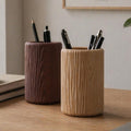 Dark and light wood grain pencil pots holding pens on a desk